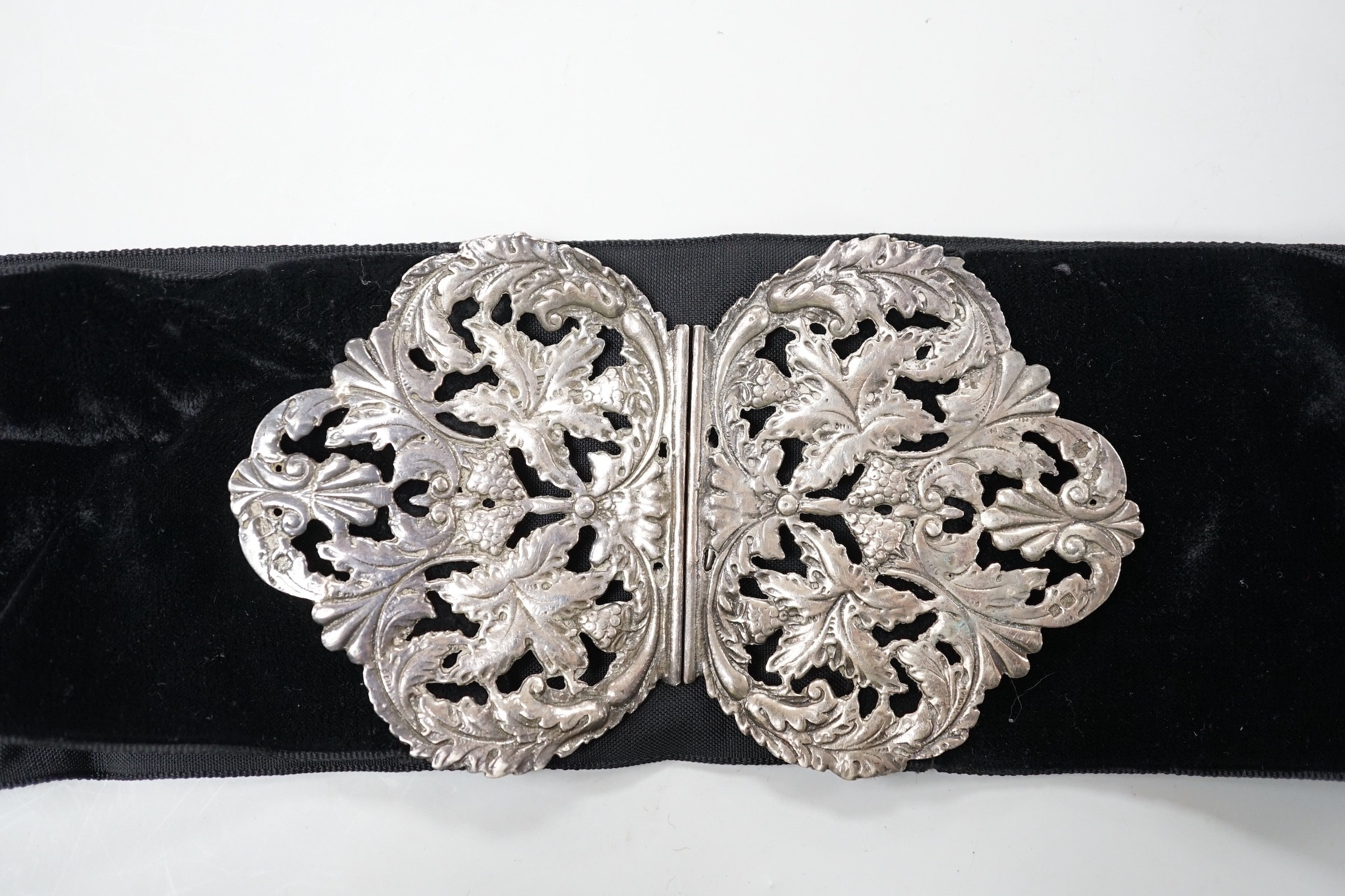 A late Victorian pierced silver belt buckle, on a black sash belt, James Deakin & Sons, Chester, 1895 (a.f.), buckle 13cm.